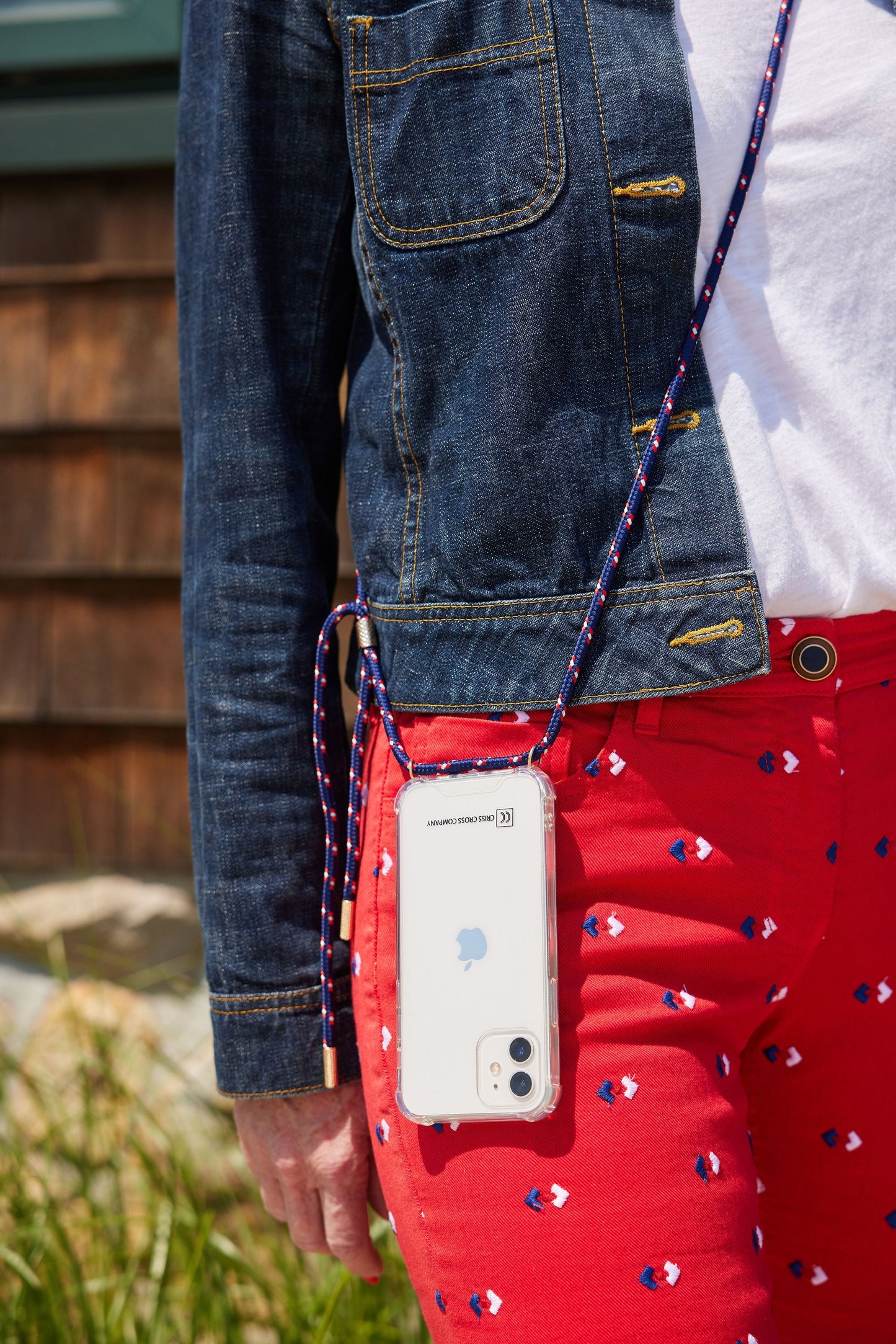 Phone case with attached stretchy strap in use, featuring customizable strap colors and metal options.