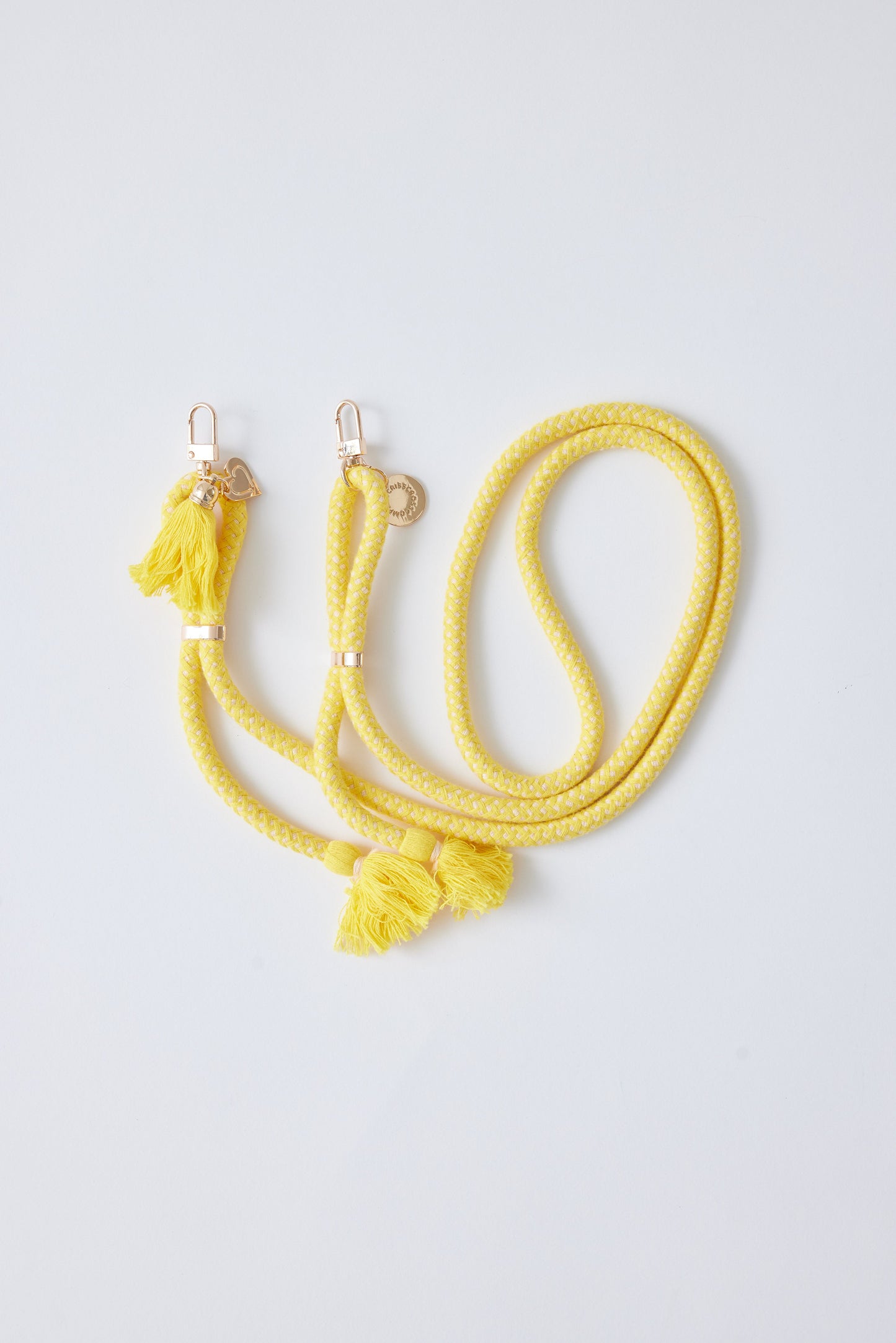 Detachable cotton phone strap with double carabiners and tassels in yellow.
