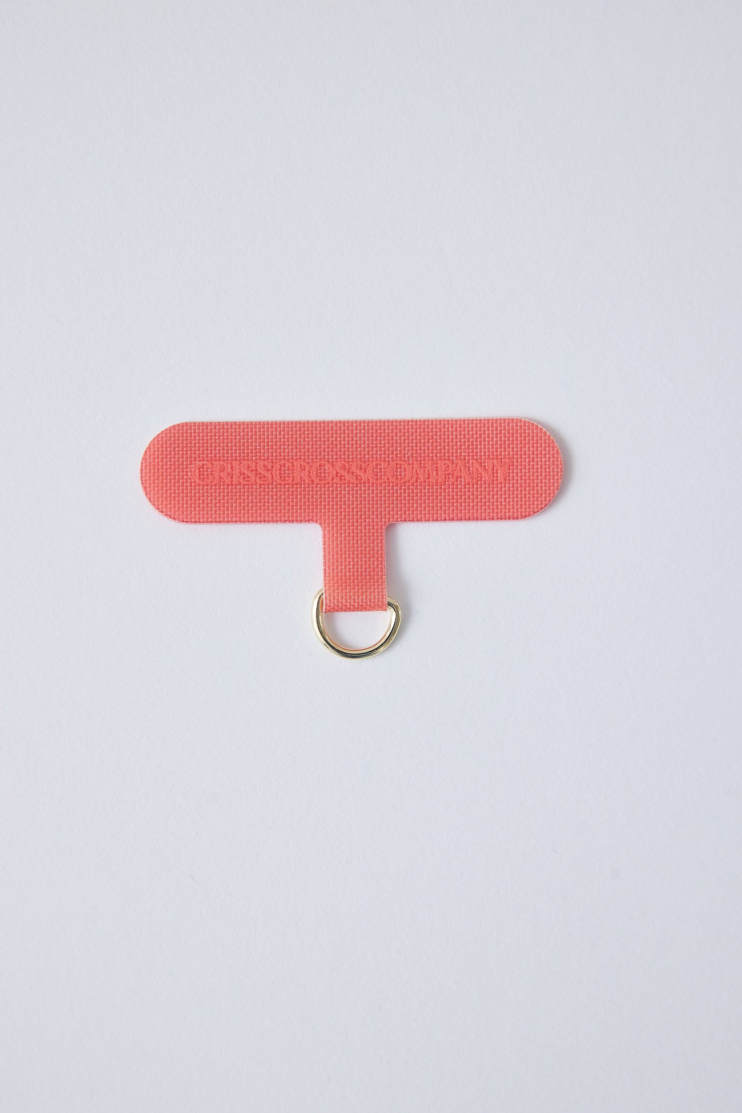 Single Universal Phone Adapter in coral color for secure phone attachment.