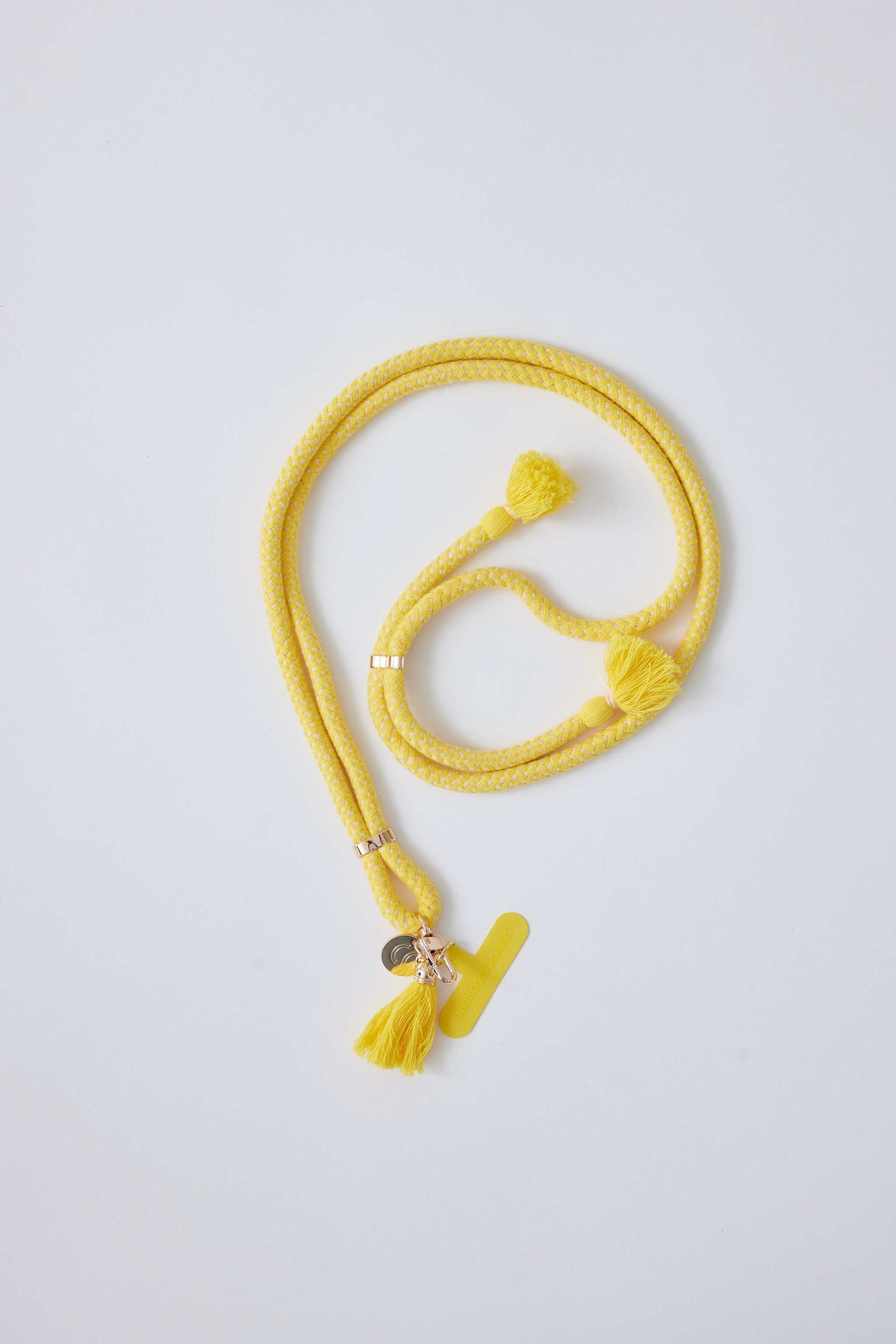 Yellow cotton phone strap with universal phone patch adapter.