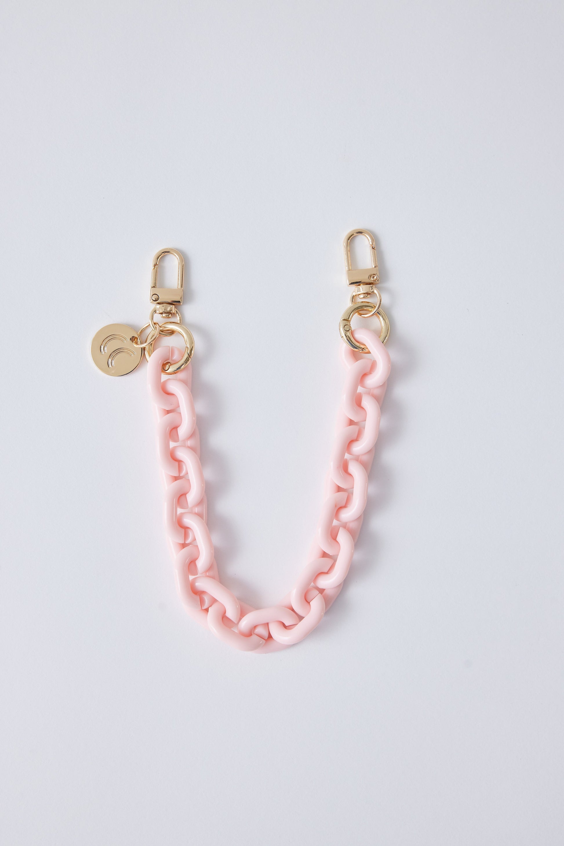 Detachable phone wristlet with pink chain and gold clasps.