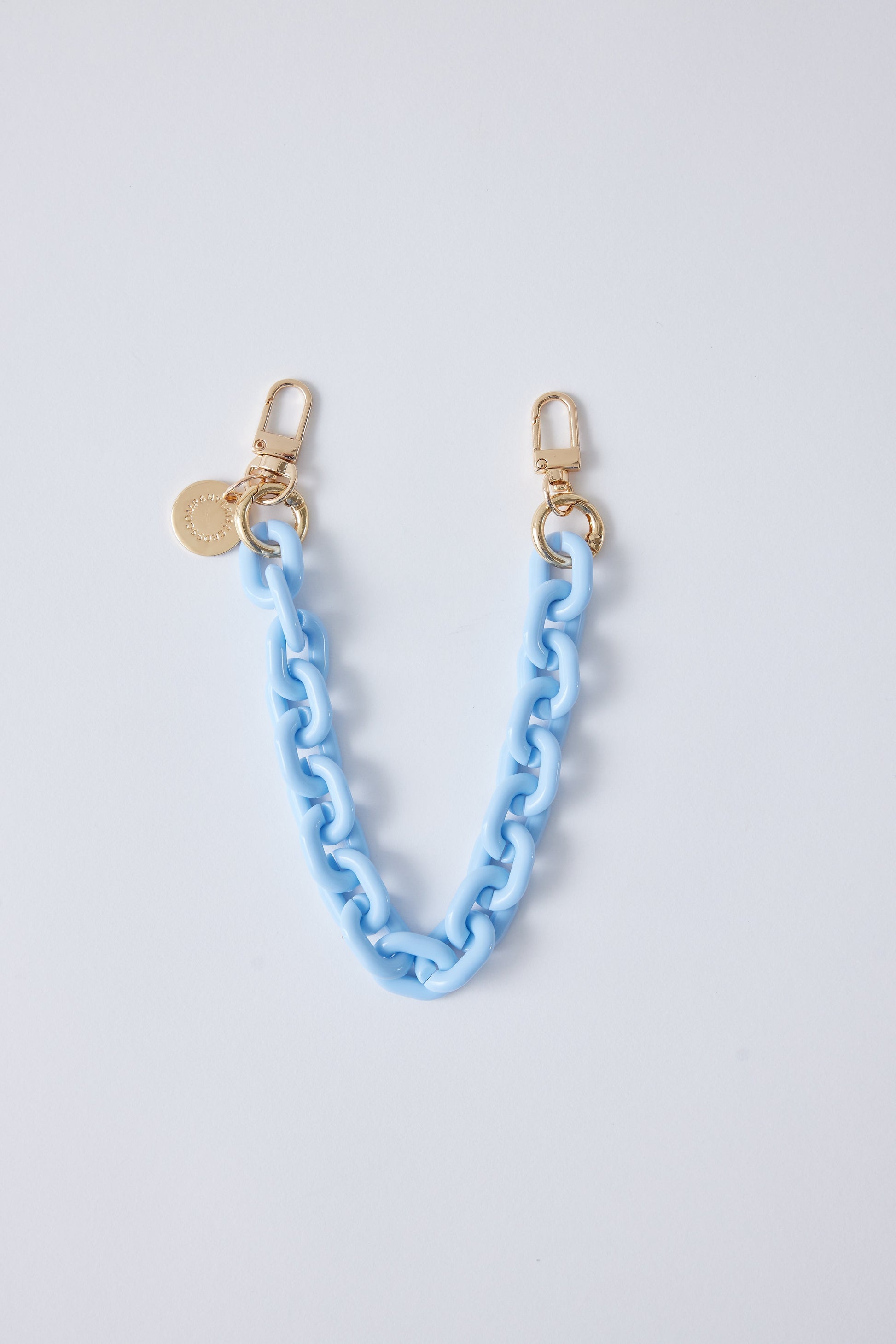 Detachable phone wristlet with blue chain and gold clips.