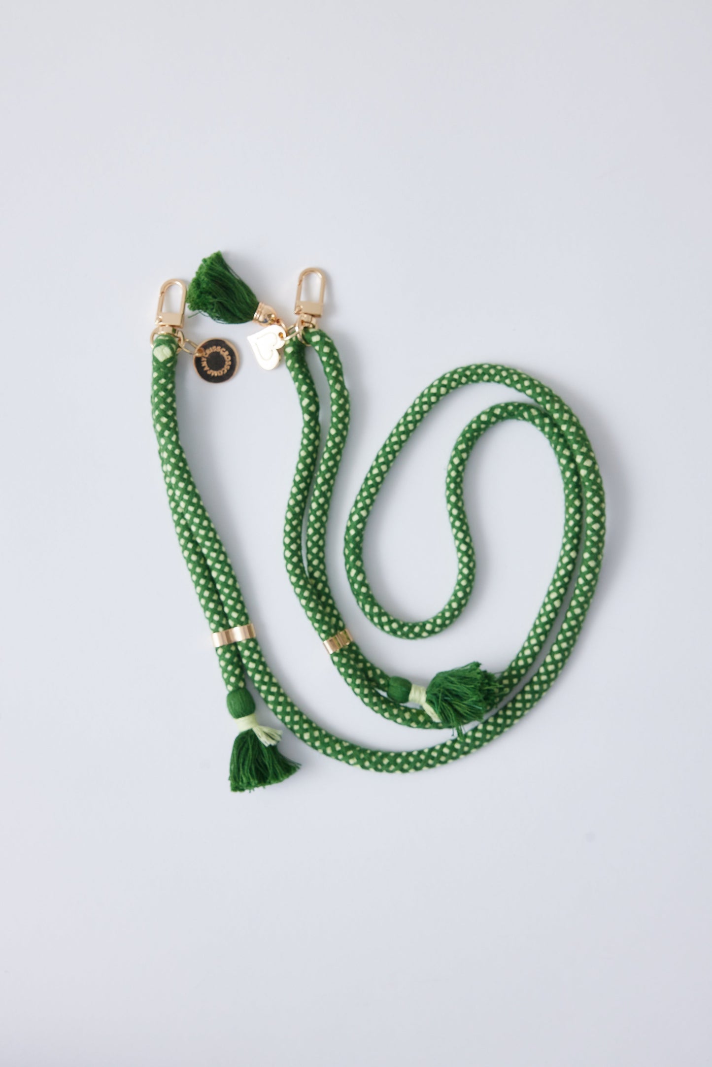 Cotton phone strap with double carabiners and detachable design, featuring tassels and heart charm.