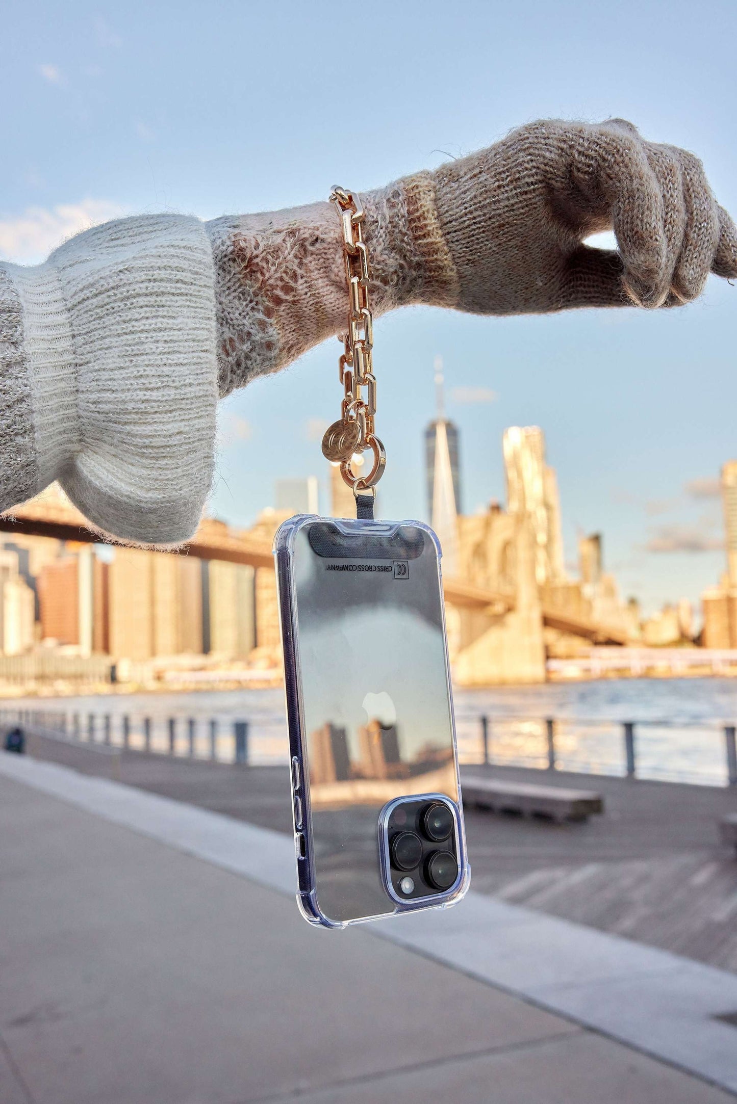 Gold Wristlet Ava attached to phone case, blending style and functionality.