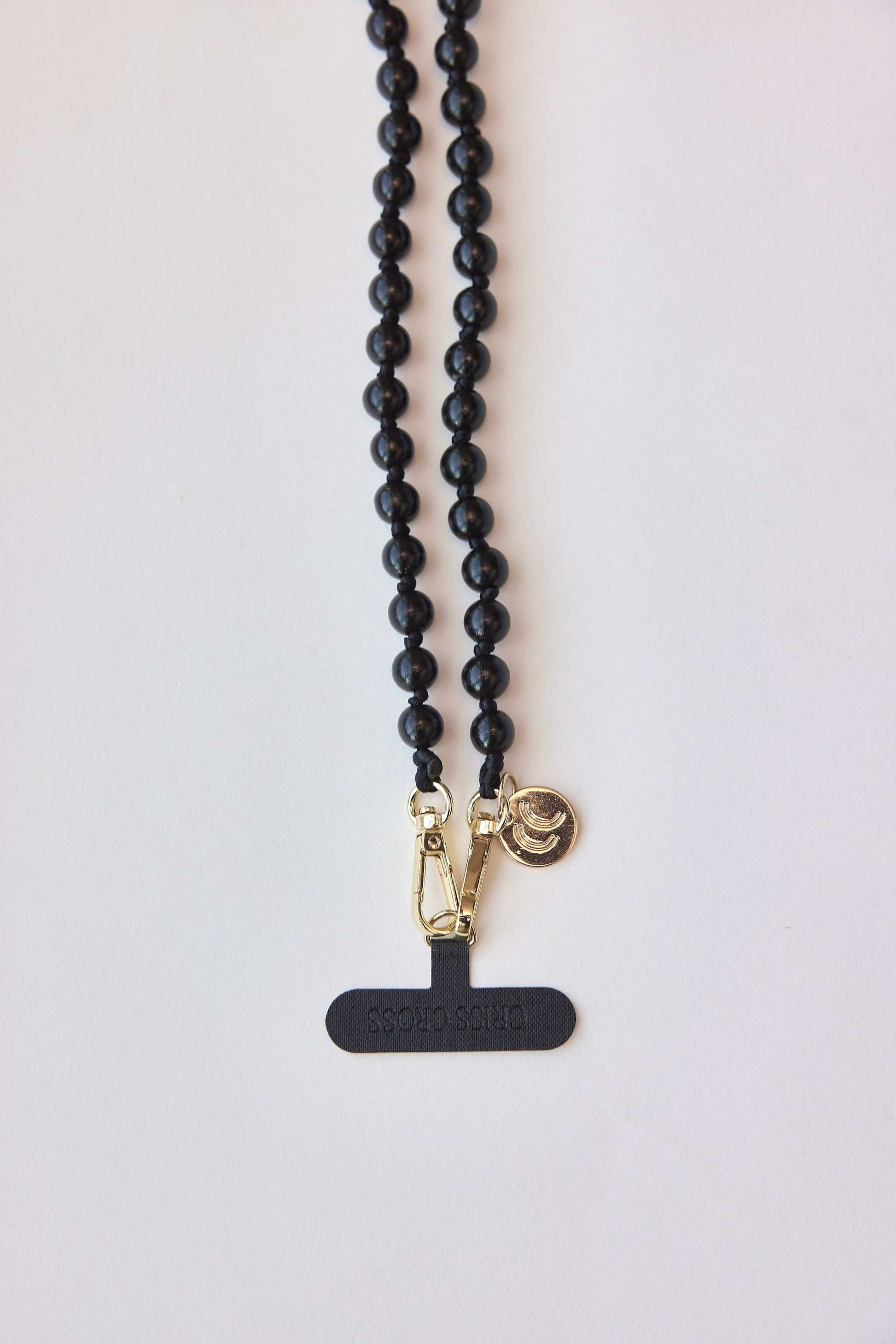 Detachable black beaded necklace with gold carabiners.