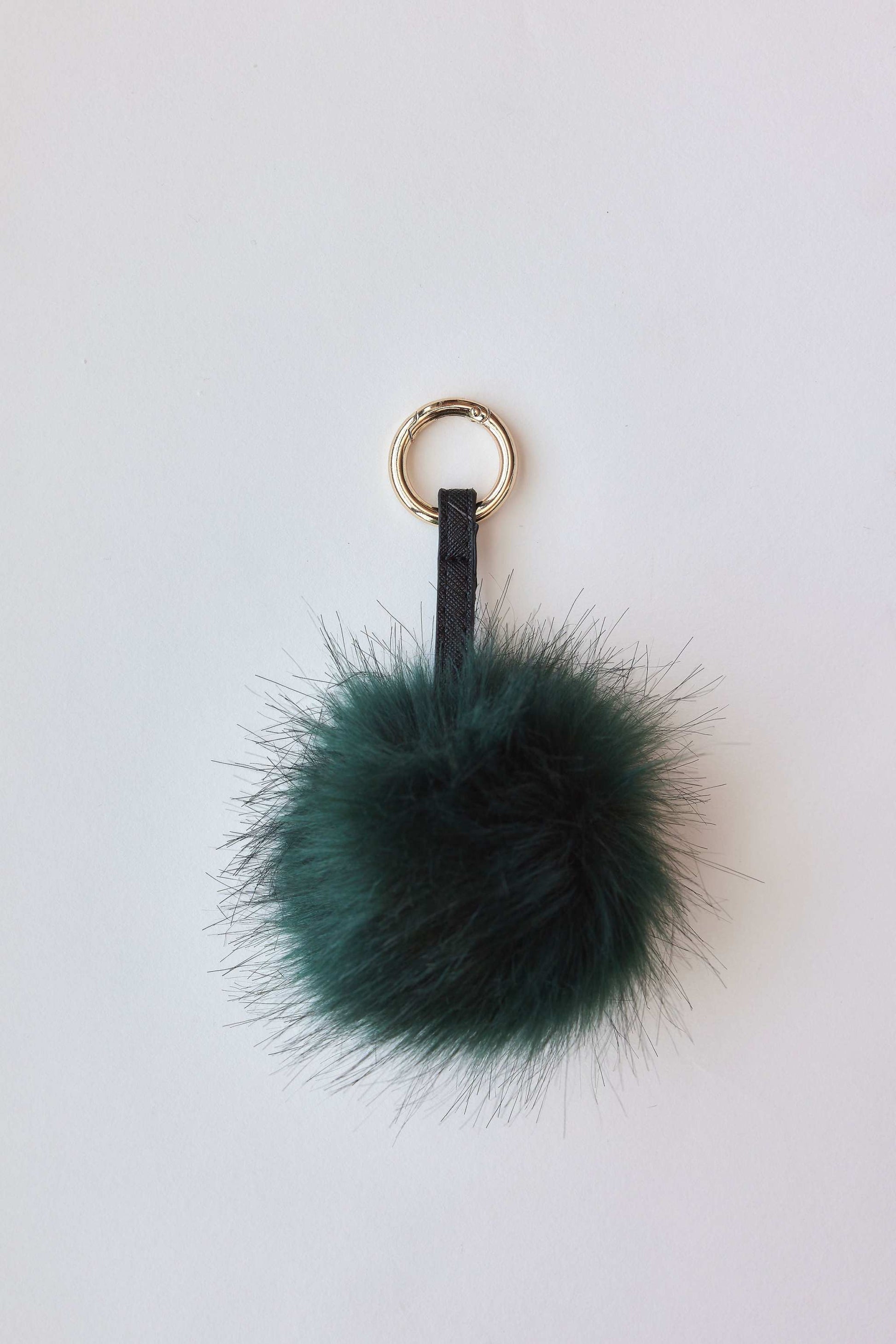 Faux fur pom-pom accessory in green with keychain attachment.