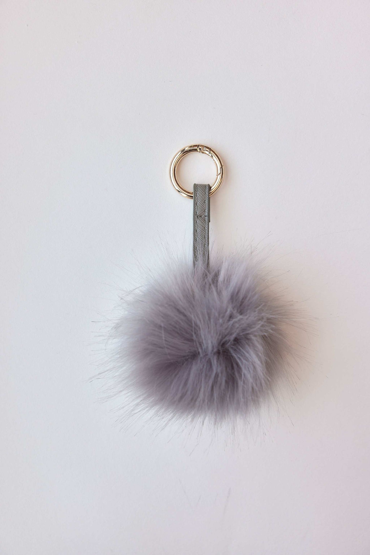 Gray faux fur pom-pom accessory with keychain attachment.