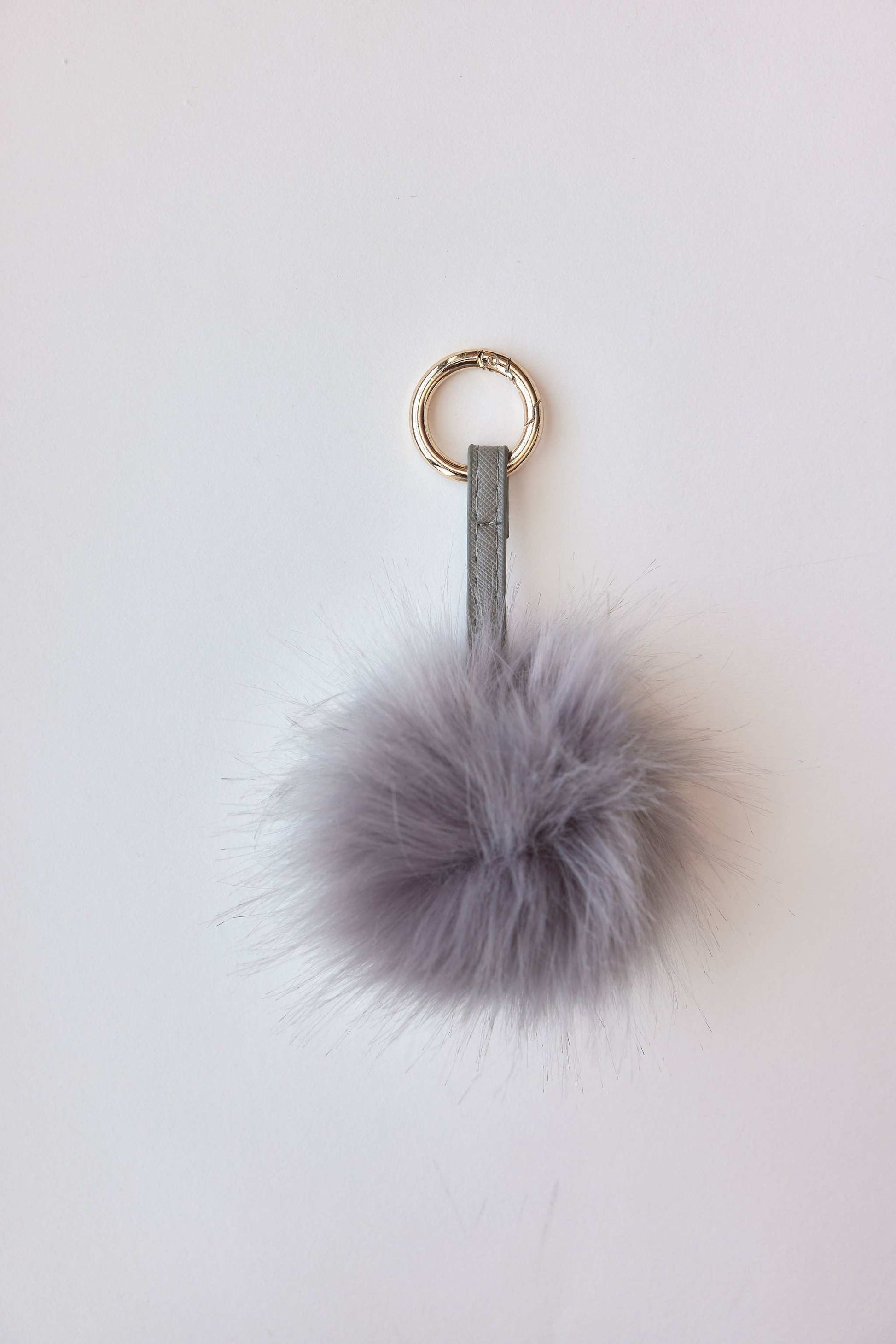 Gray faux fur pom-pom accessory with keychain attachment.