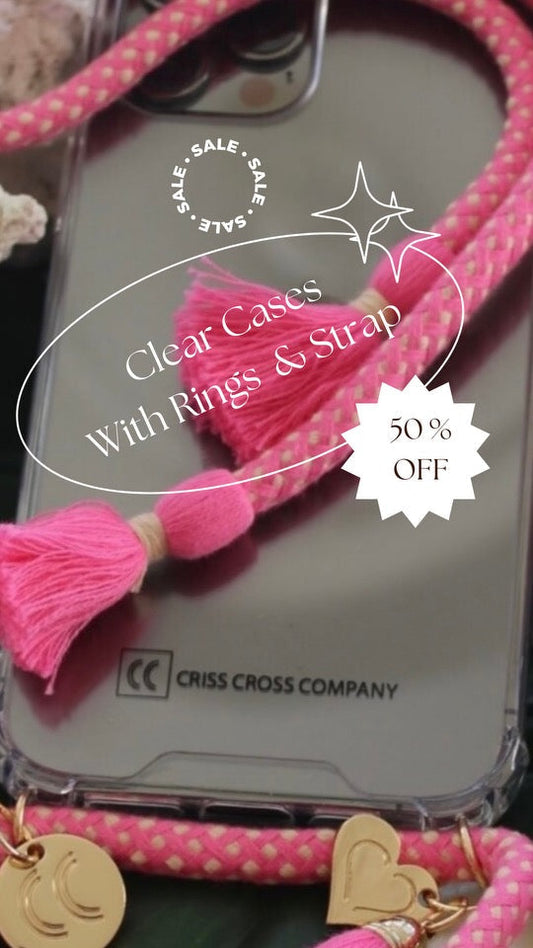 Phone case with attached cotton strap, tassels, and heart charm.