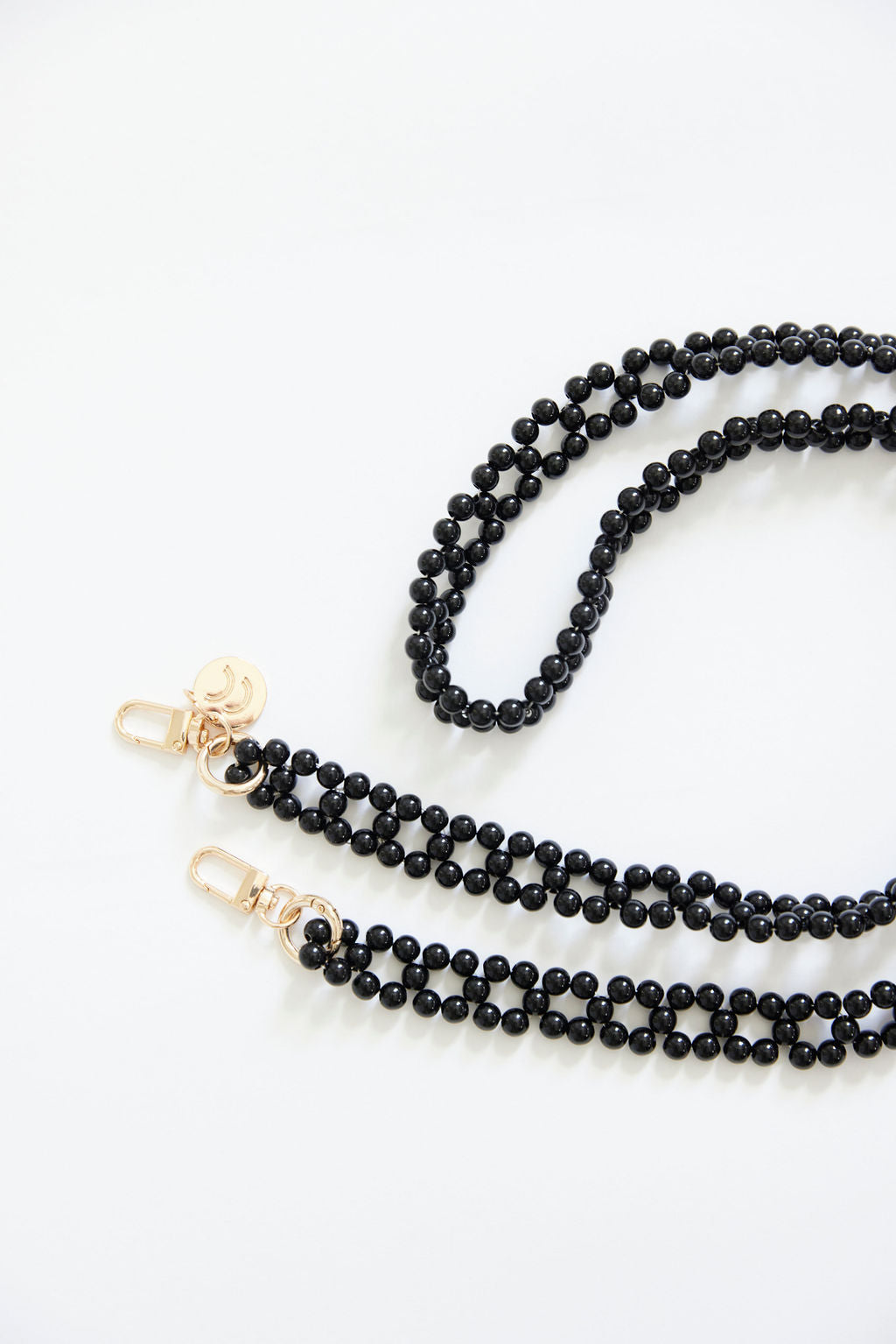 Detachable beaded chains with black beads and golden carabiners.
