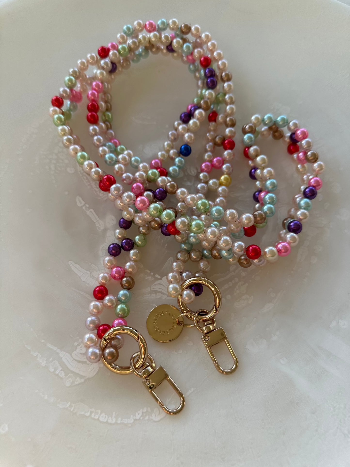 Detachable beaded phone chain in mixed colors with metal rings.
