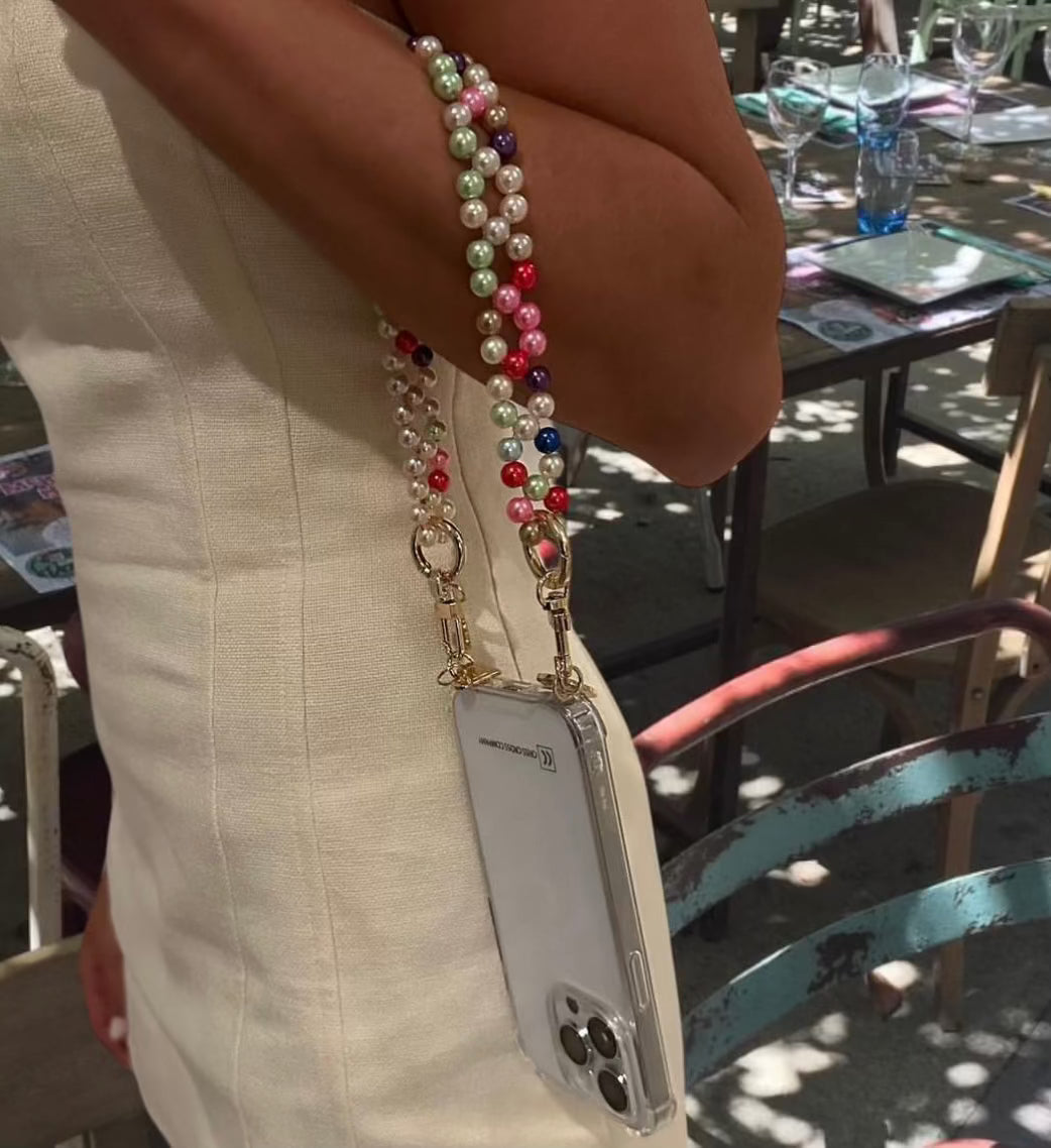 Detachable candy wristlet with colorful beads on arm, holding a phone.