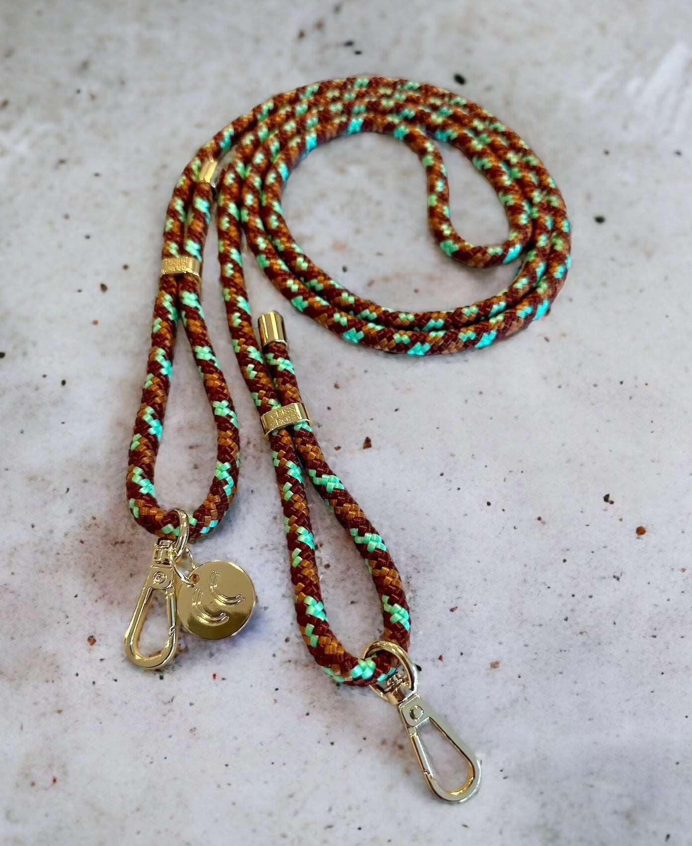 Detachable camouflage poly straps with gold carabiners.