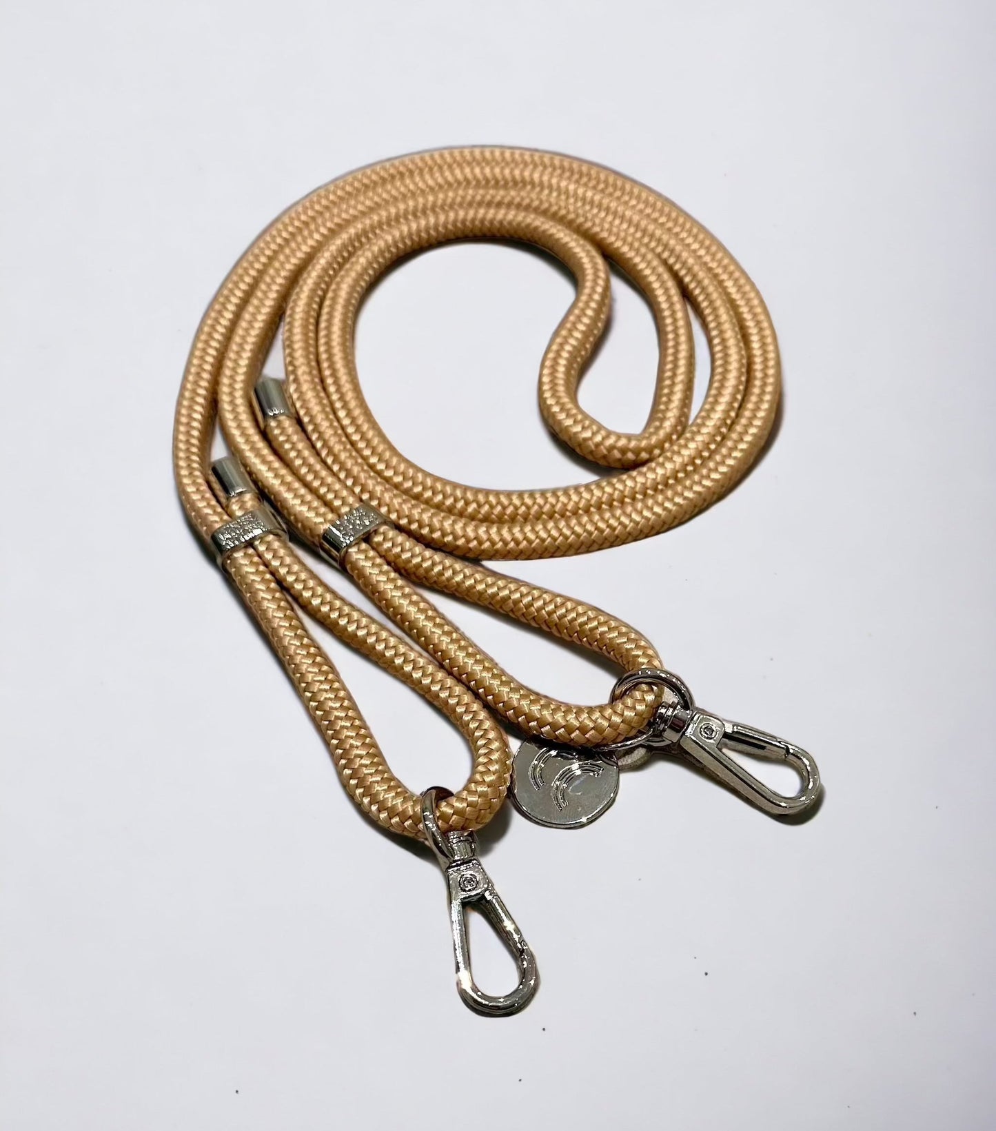 Detachable poly straps in sand color with silver carabiners.