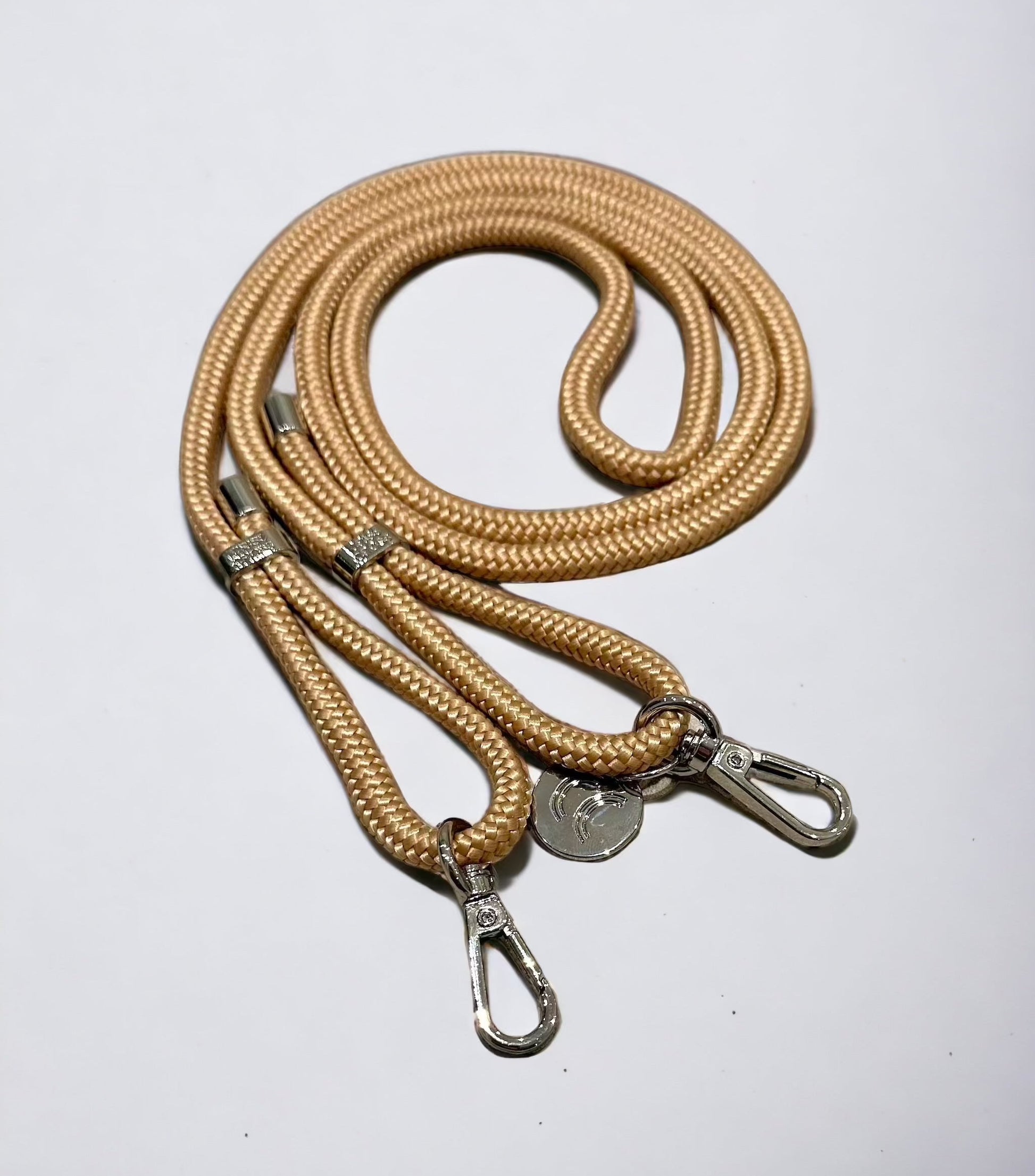 Detachable poly straps in sand color with silver carabiners.
