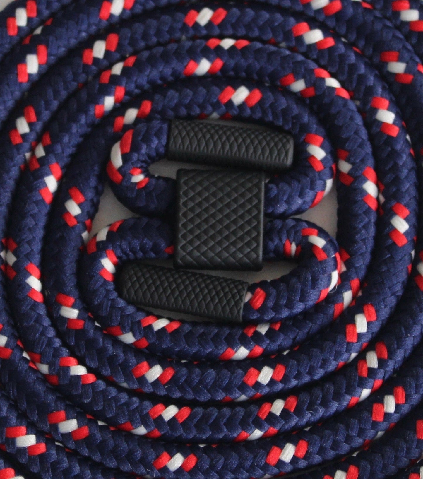 Phone case with attached stretchy strap featuring a braided design in red, white, and blue.