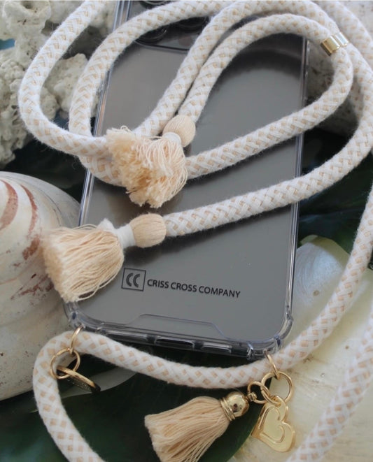 Phone case with attached cotton strap, tassels, and heart charm.