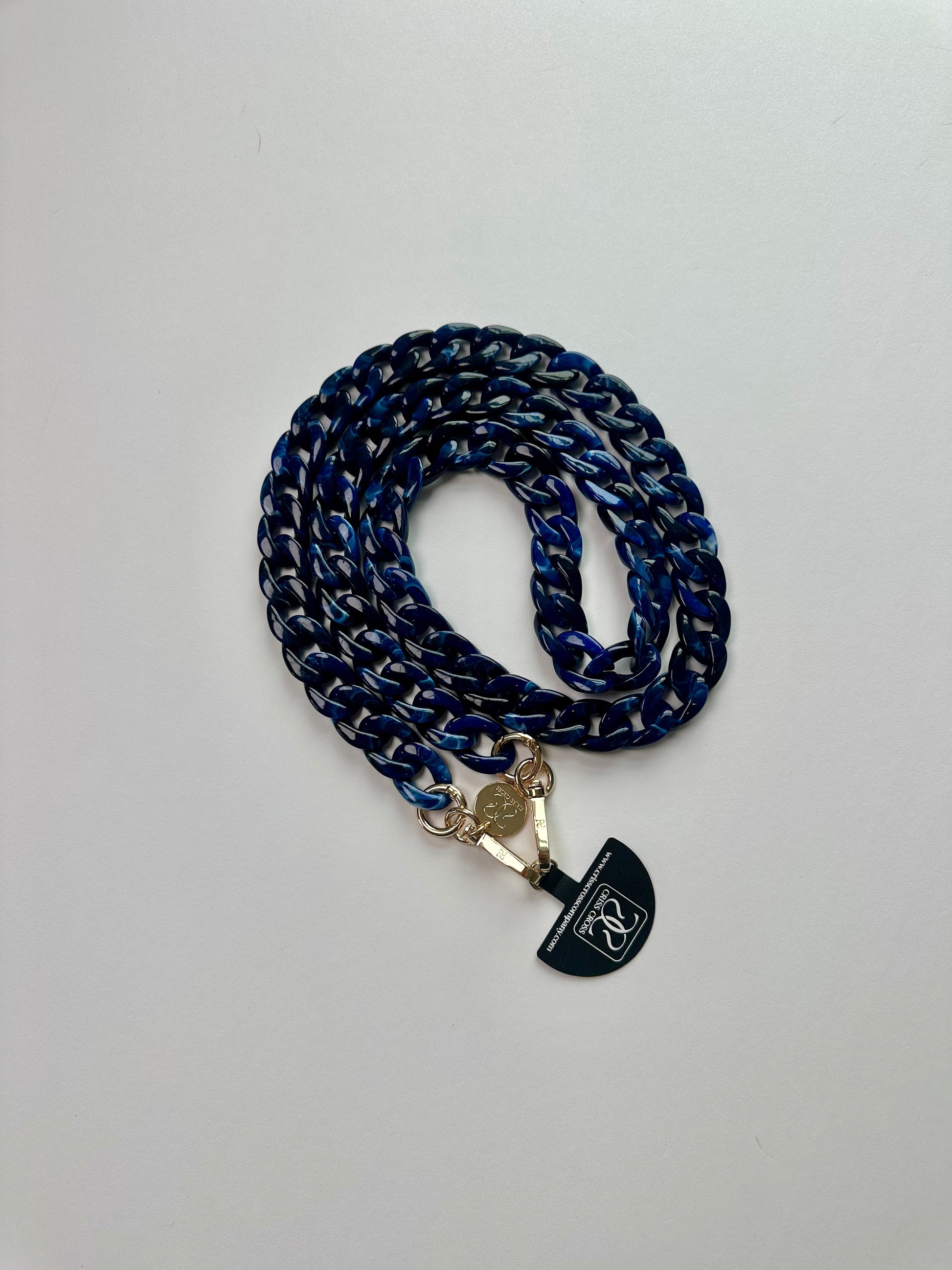 Glossy detachable acrylic phone chain with universal adapter and alloy carabiners attached to a smartphone case