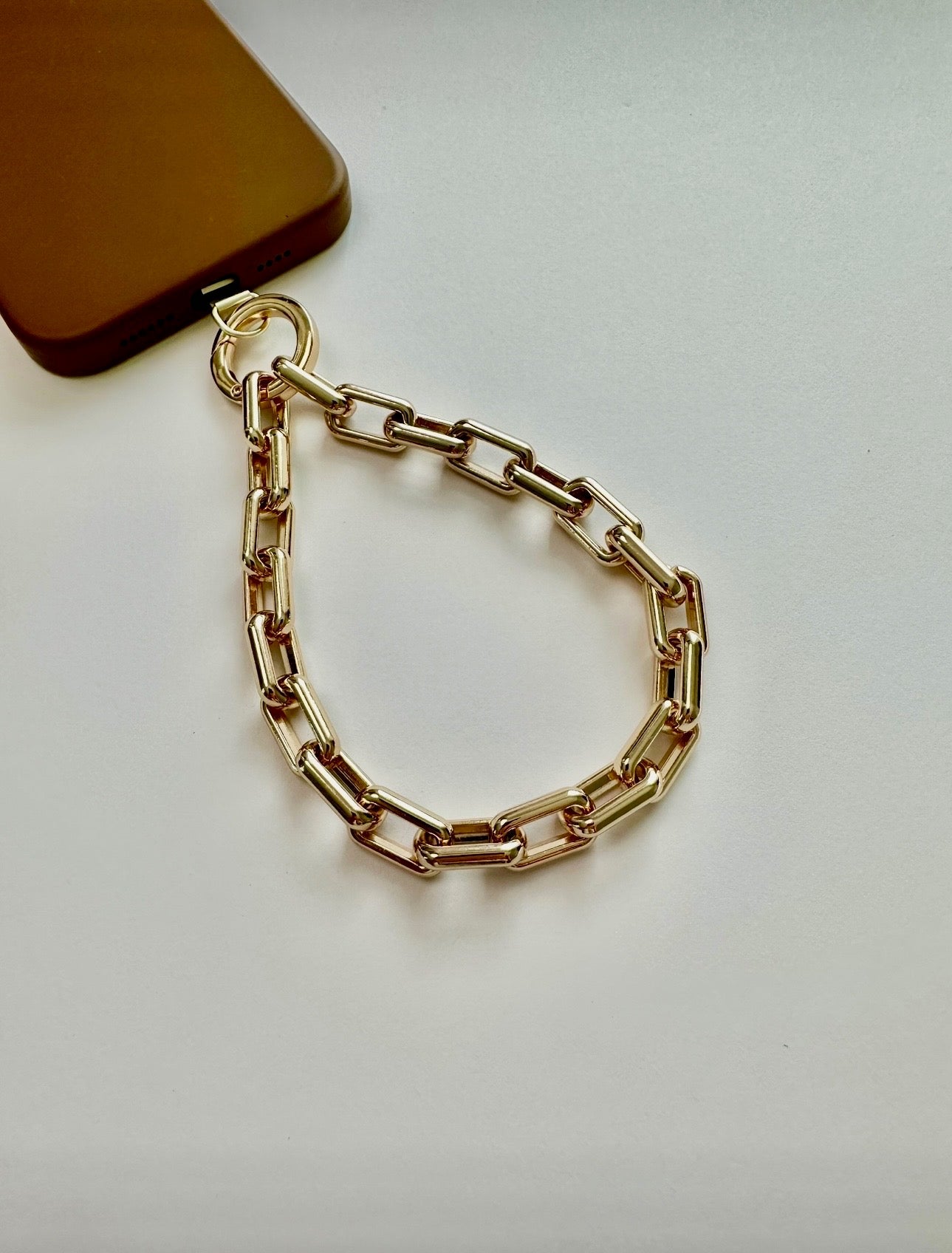 Gold Wristlet Ava phone accessory with universal adapter and gold-tone alloy links