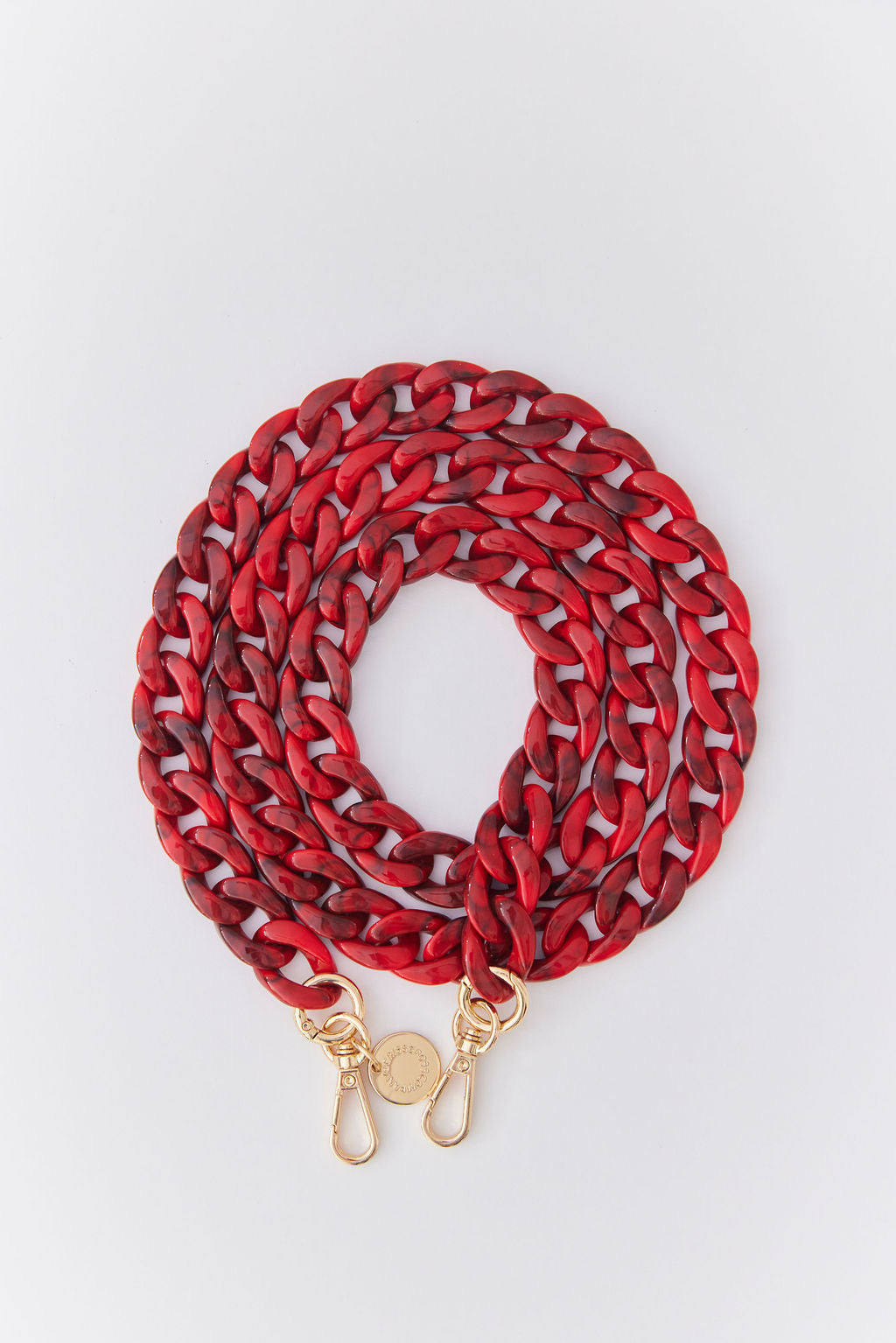 Detachable red acrylic phone chain with golden rings and carabiners for stylish phone accessorizing