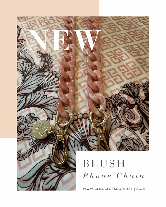 Detachable acrylic phone chains with golden rings and carabiners on patterned fabric background.