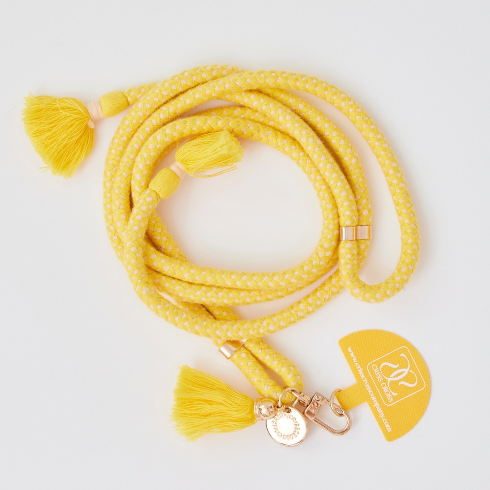 Adjustable cotton phone strap with universal adapter and decorative tassels attached to smartphone